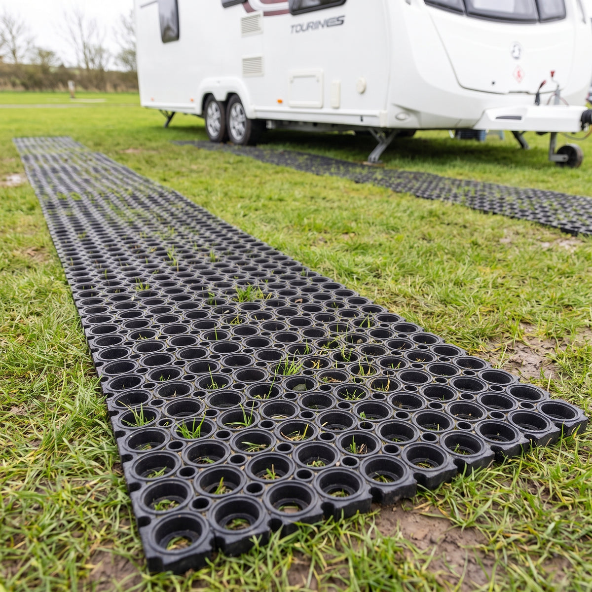 Rubber grass mats laid as wheel tracks on a grass caravan pitch