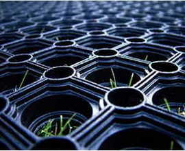 Grass growing up through the cells of a rubber grass protection mat