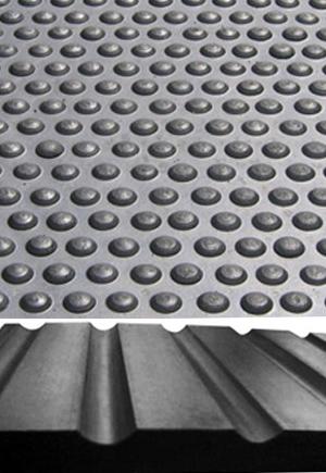 Reversible 6ft x 4ft rubber stable mat close-up showing the raised bubble stud top and the ribbed, fluted hammer underside